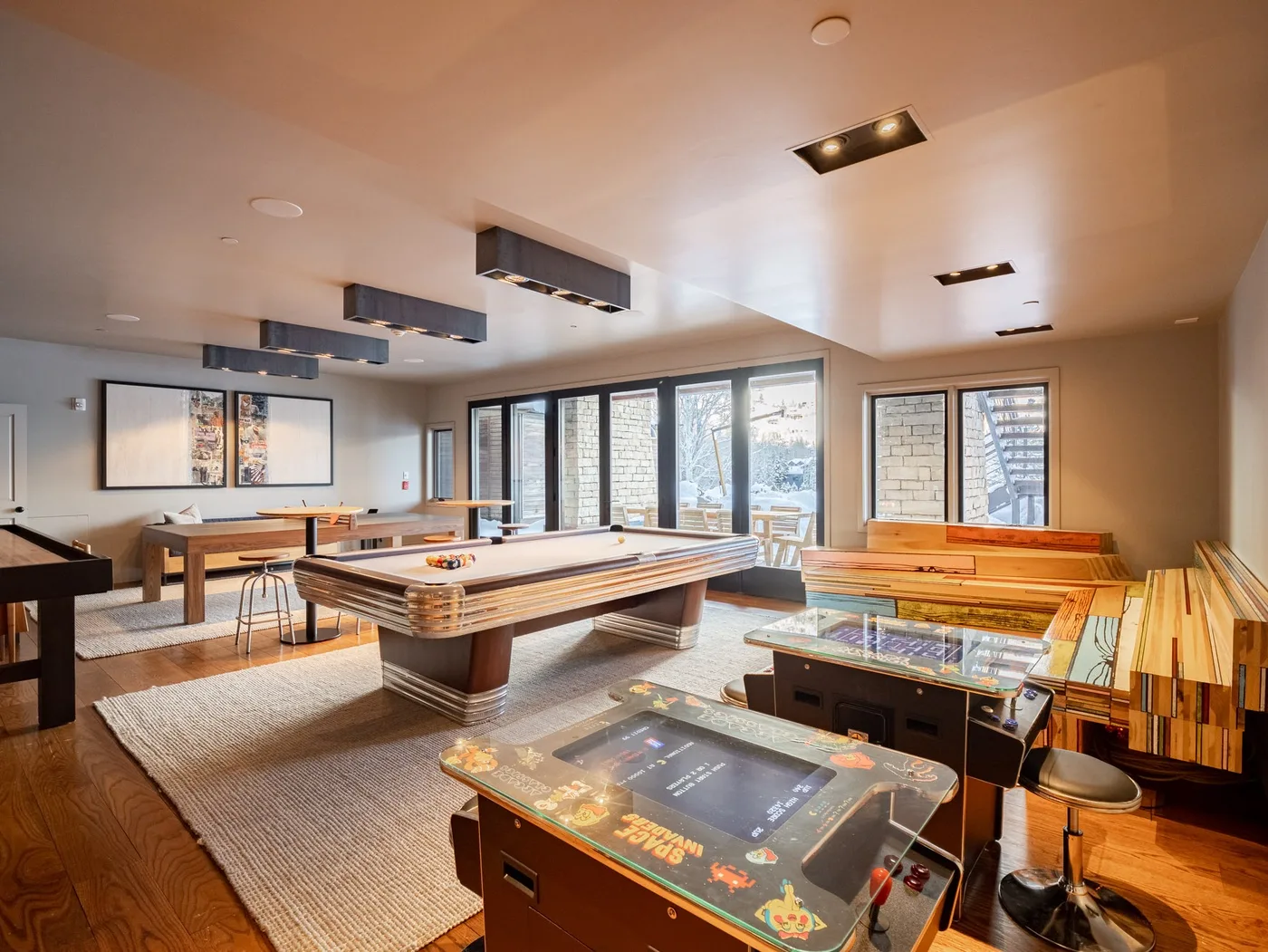 A bright game room with pool tables and large windows.