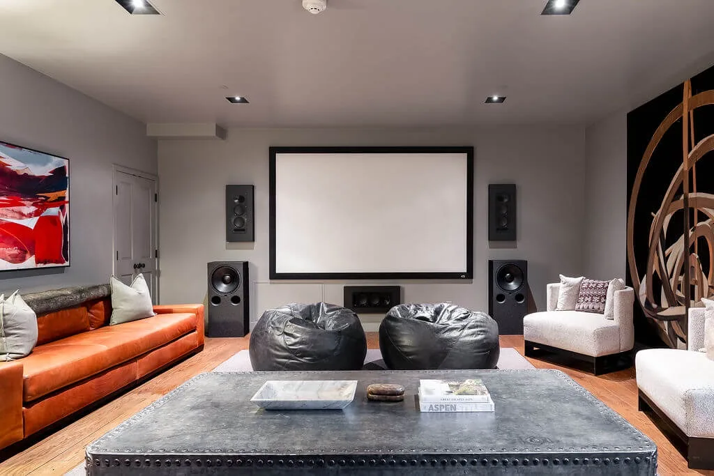 A home theater room with a large projection screen and seating.