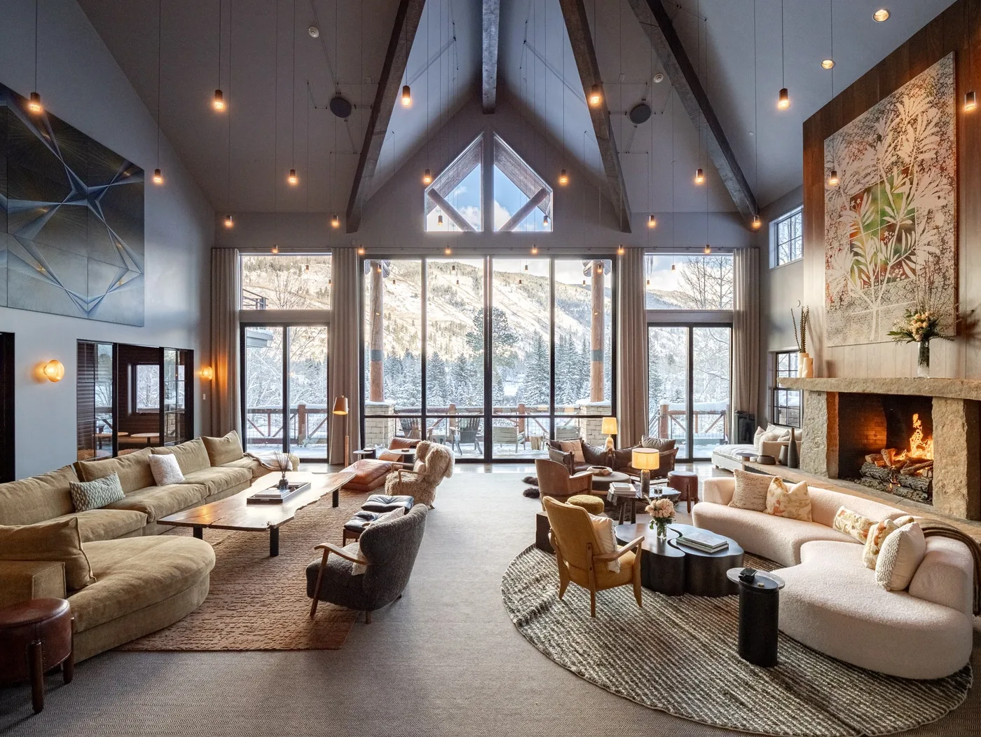 A spacious living room with seating, tall windows, and a fireplace.
