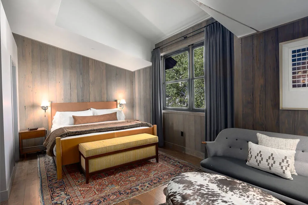 A bedroom with a bed, a window, and seating.