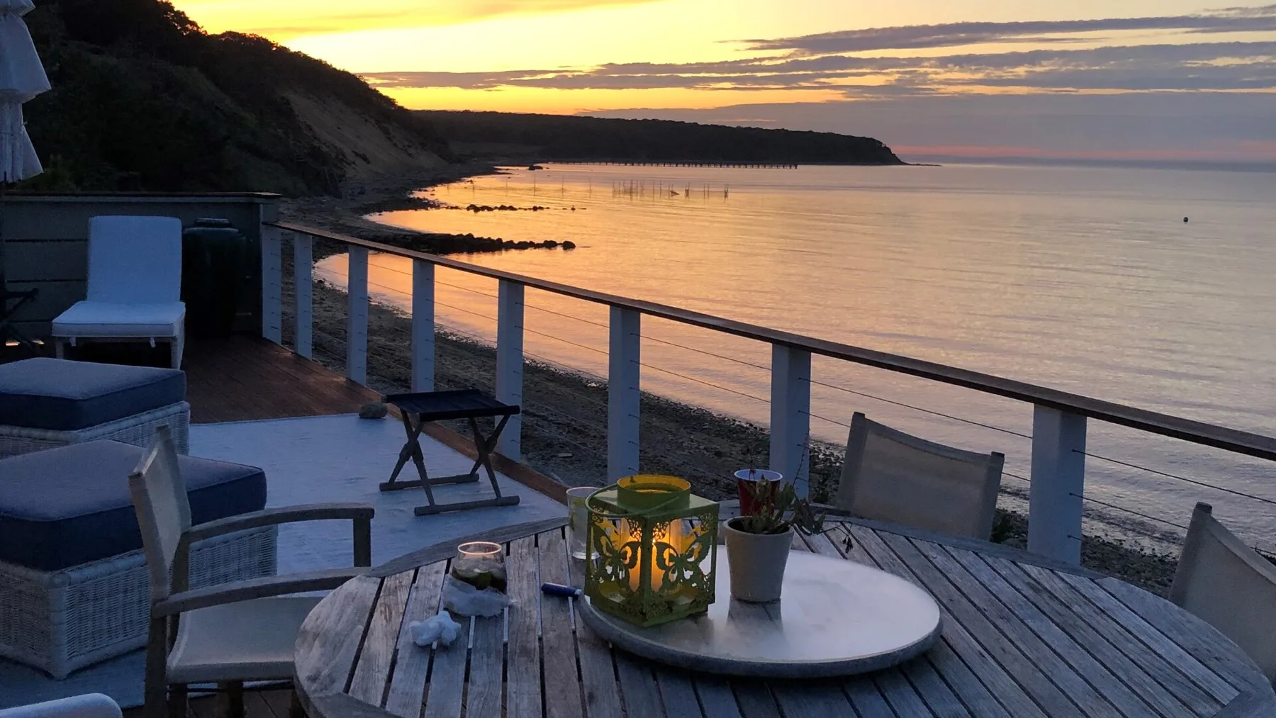 Un patio junto al mar da al litoral y al agua tranquila al atardecer.