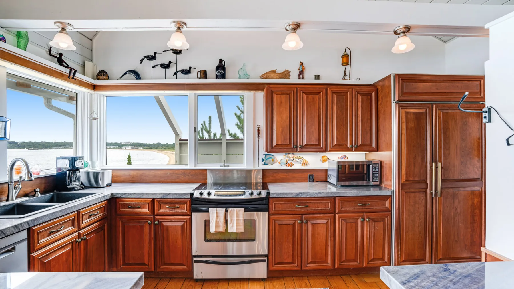 Una cocina con gabinetes de madera, una encimera y una ventana con vista al agua.