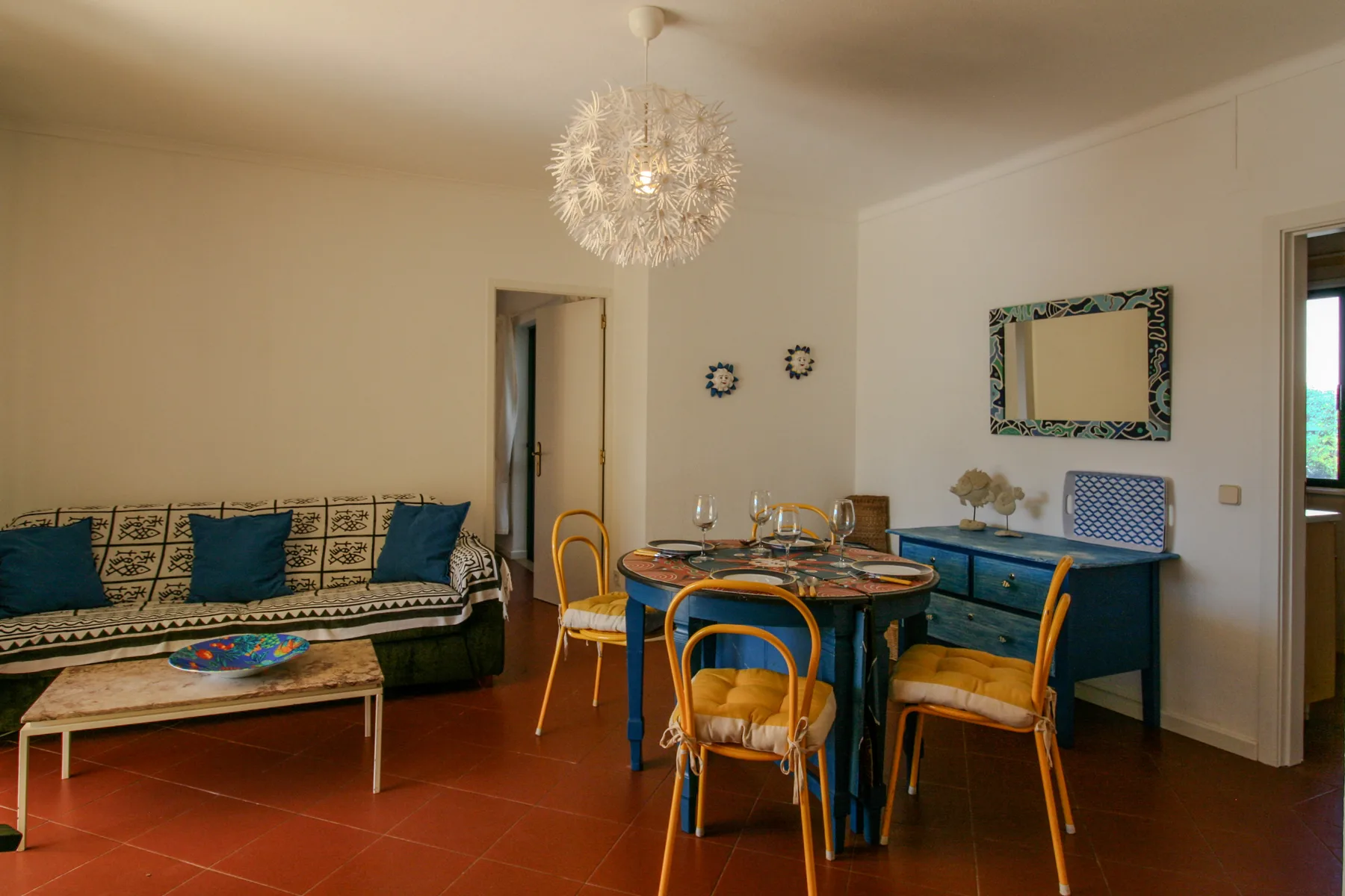 A dining and seating area with a table, chairs, and a sofa.