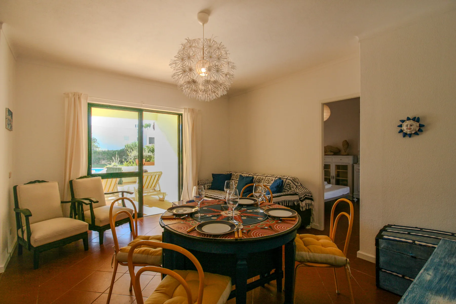 A dining and living room with a round table and seating beside sliding glass doors.