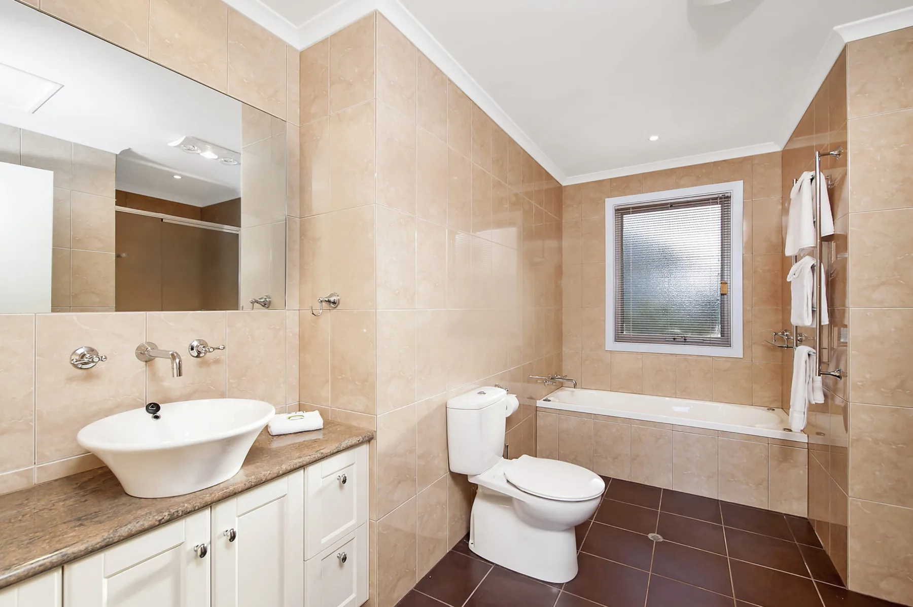 A tiled bathroom with a bathtub, toilet, and sink.