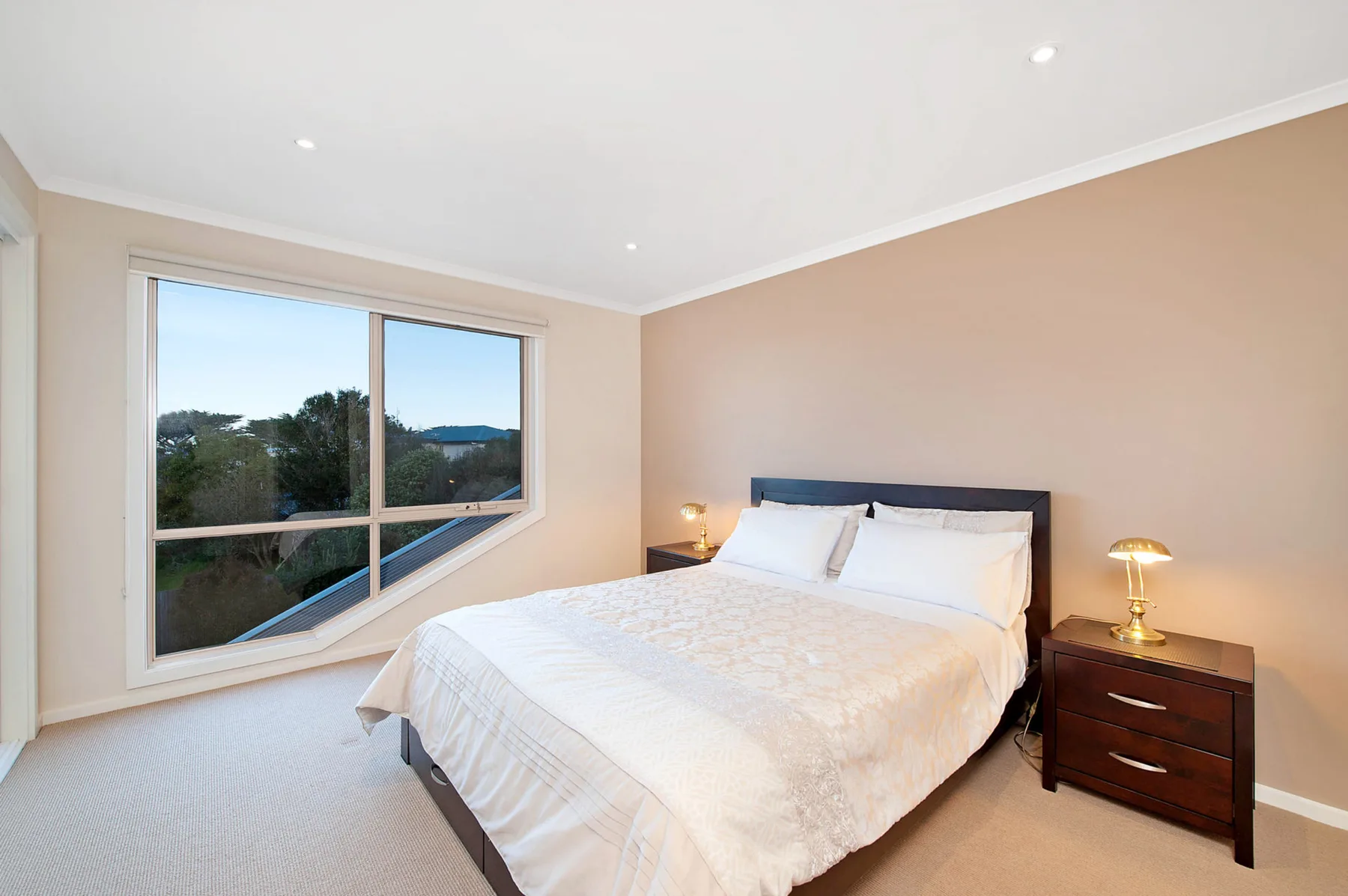 Un dormitorio luminoso con una ventana grande junto a la cama.