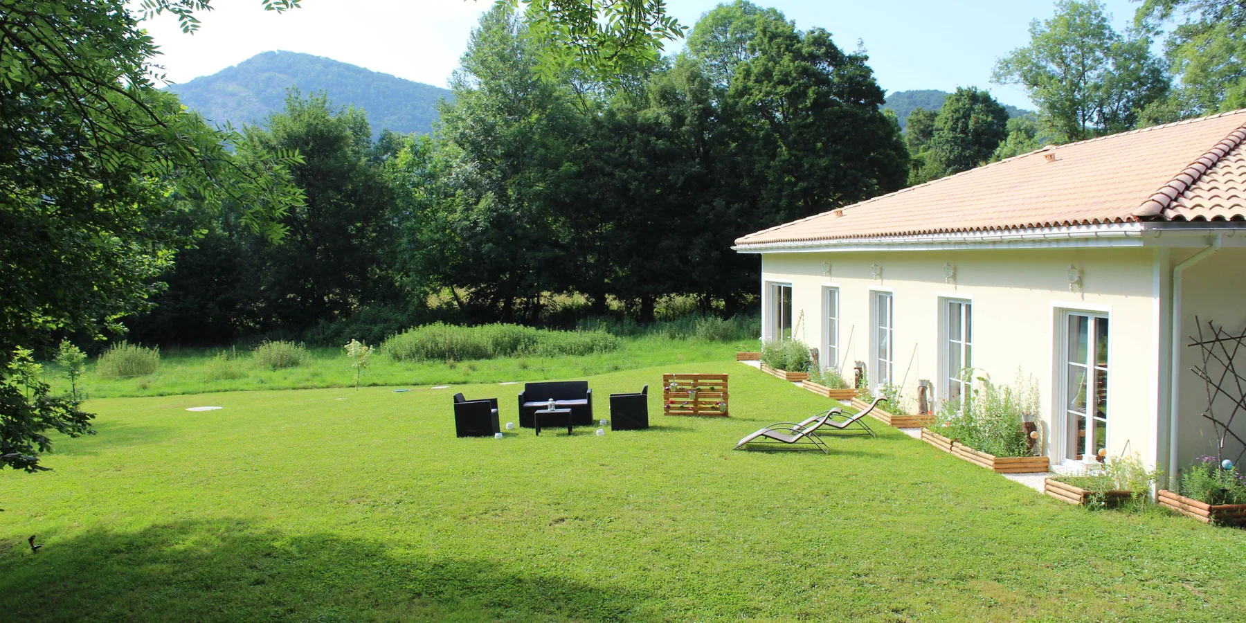 Fachada trasera con vistas al jardín y a las montañas