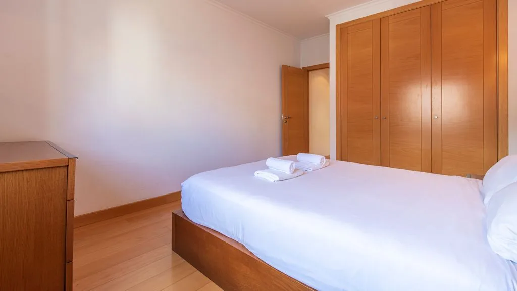 Bedroom with a bed and wooden wardrobes.