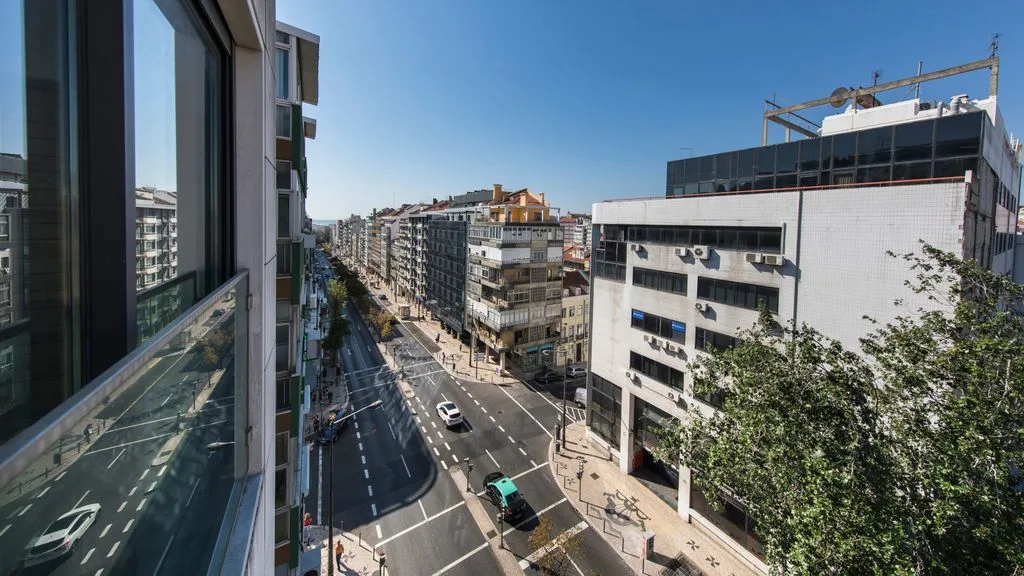 A city street viewed from above, with buildings lining the road.