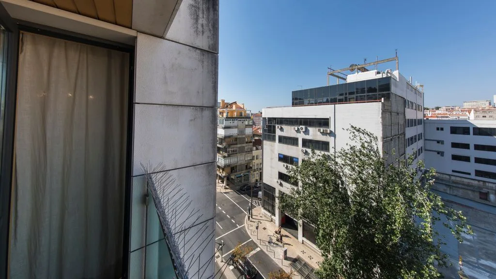 A city street and nearby buildings viewed from a window.