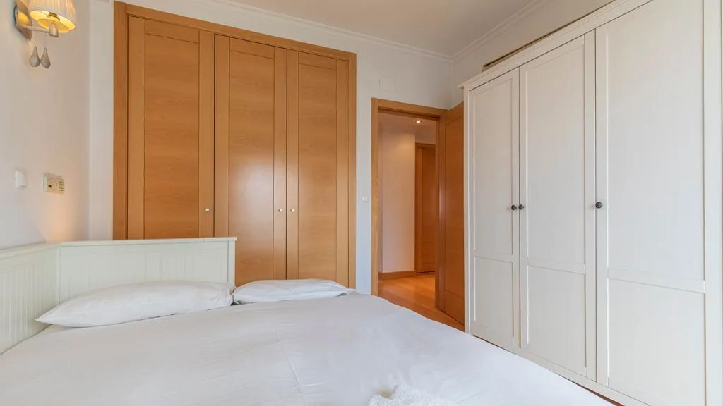 A bedroom with a bed and built-in wardrobes.