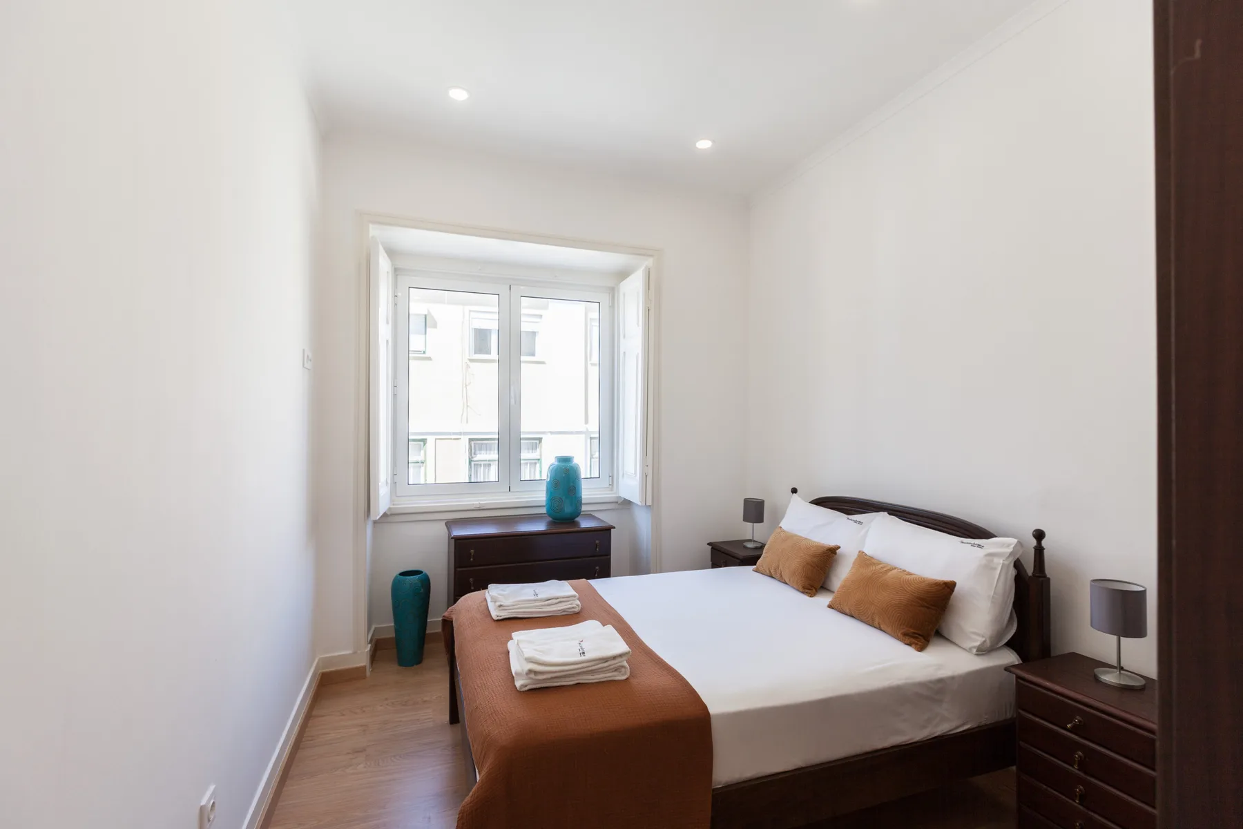 Un dormitorio luminoso con una cama y una ventana grande.