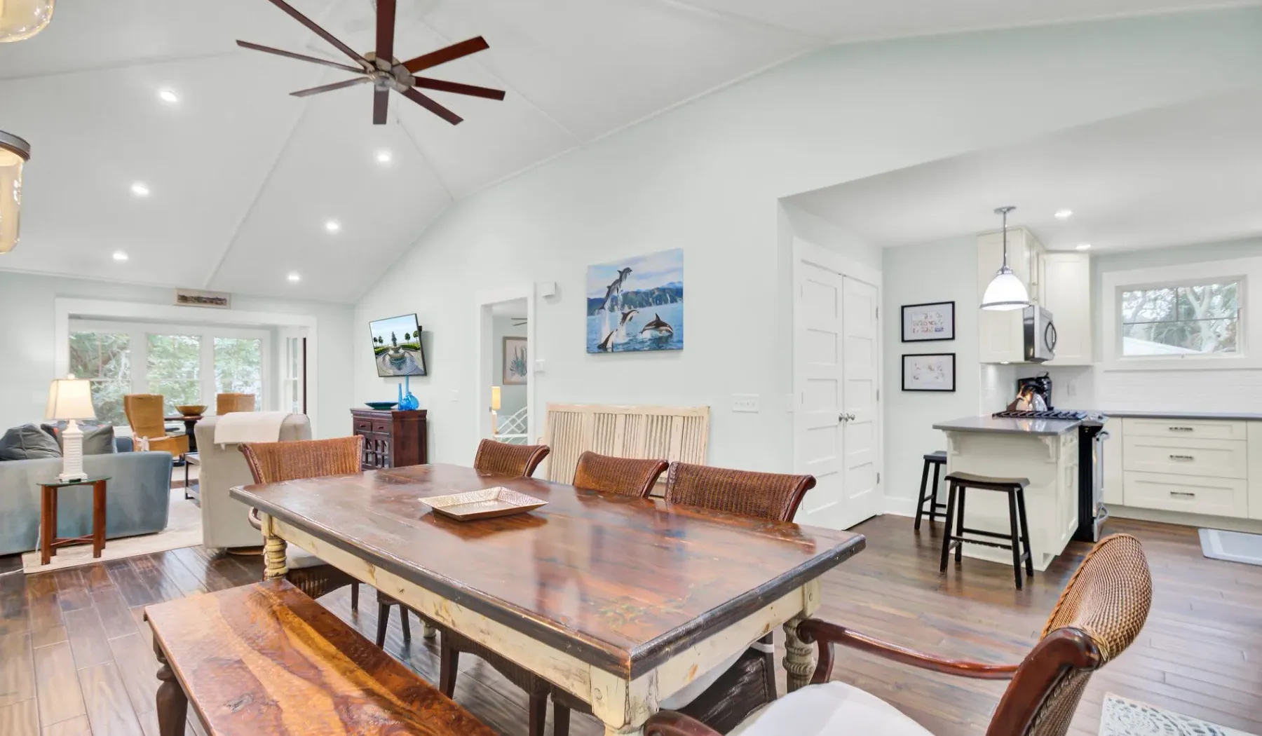 Un comedor y cocina diáfanos y luminosos, con una larga mesa de madera e isla.