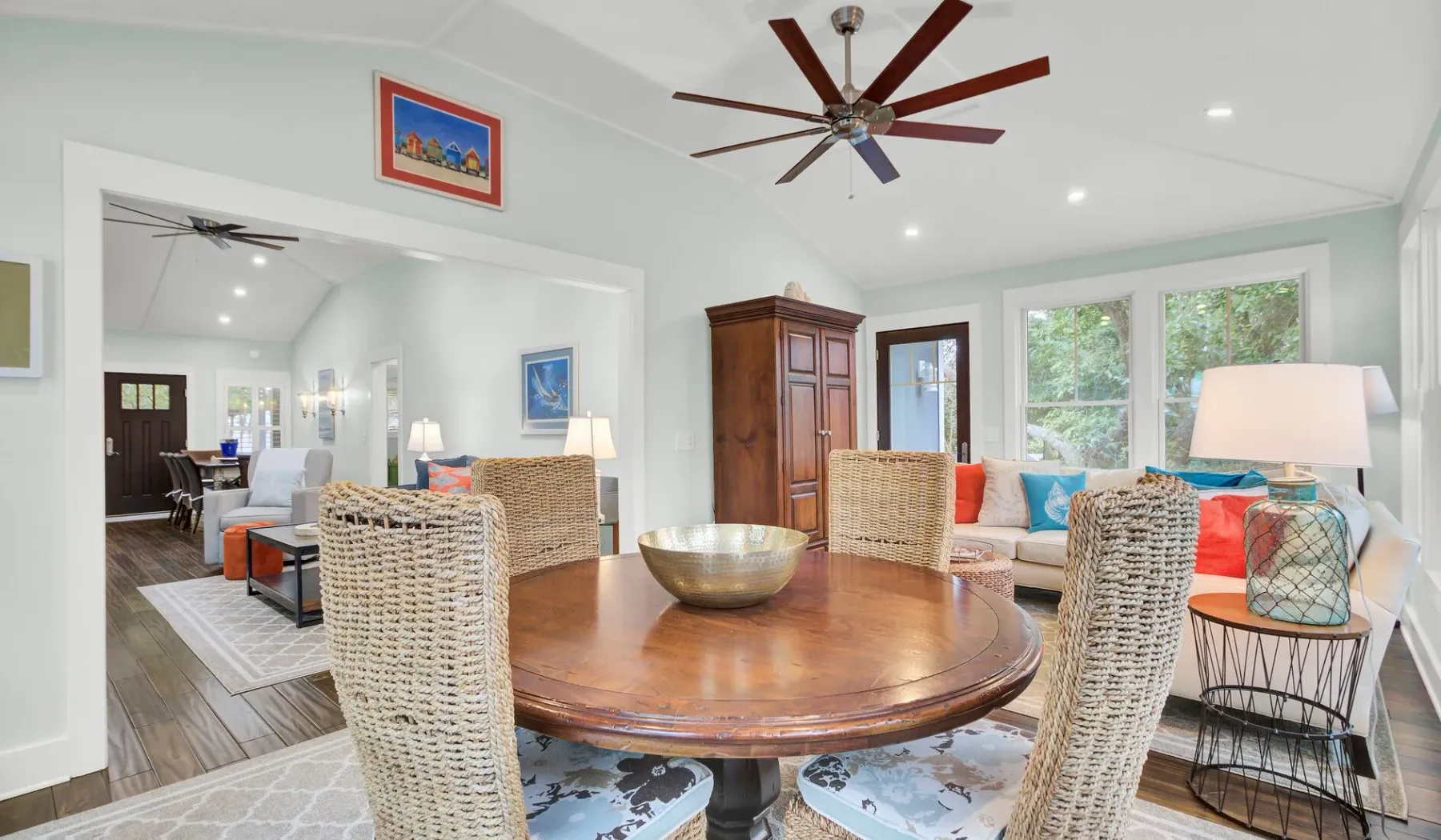 A bright dining area with a round wooden table and woven seating.