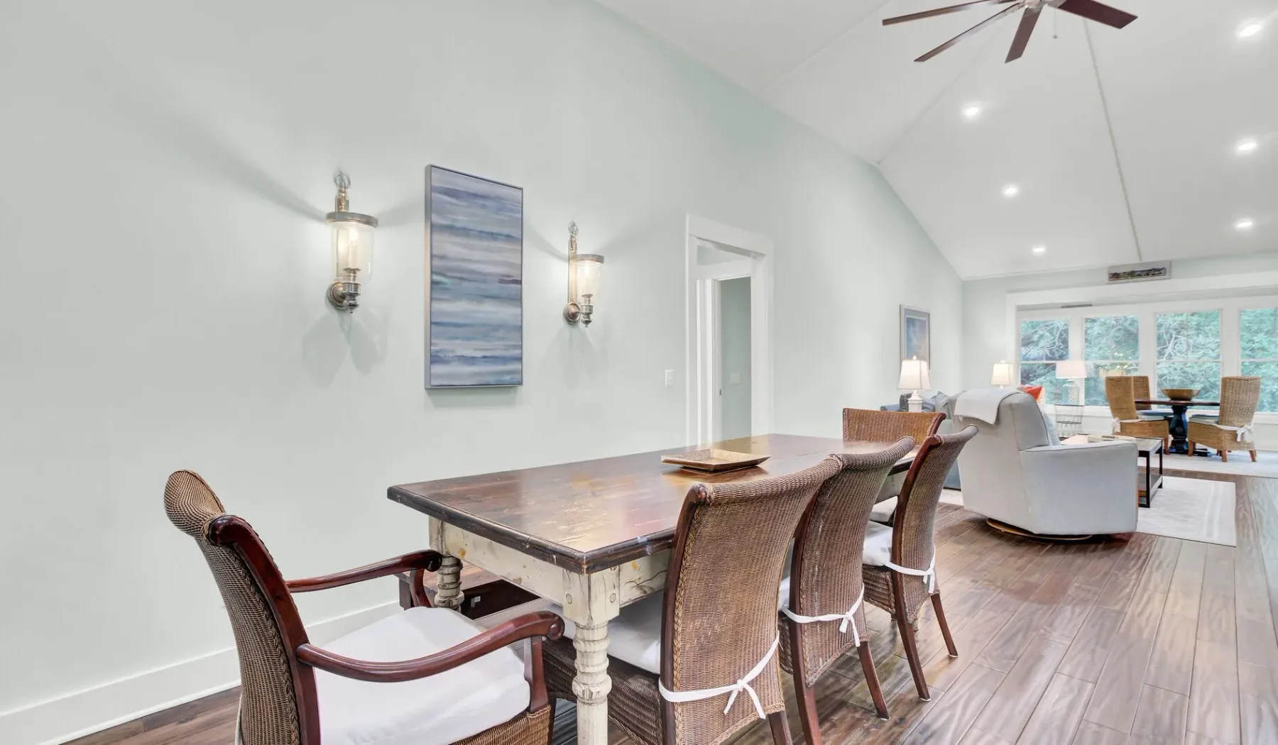 A bright dining and living area with a wooden table and seating.