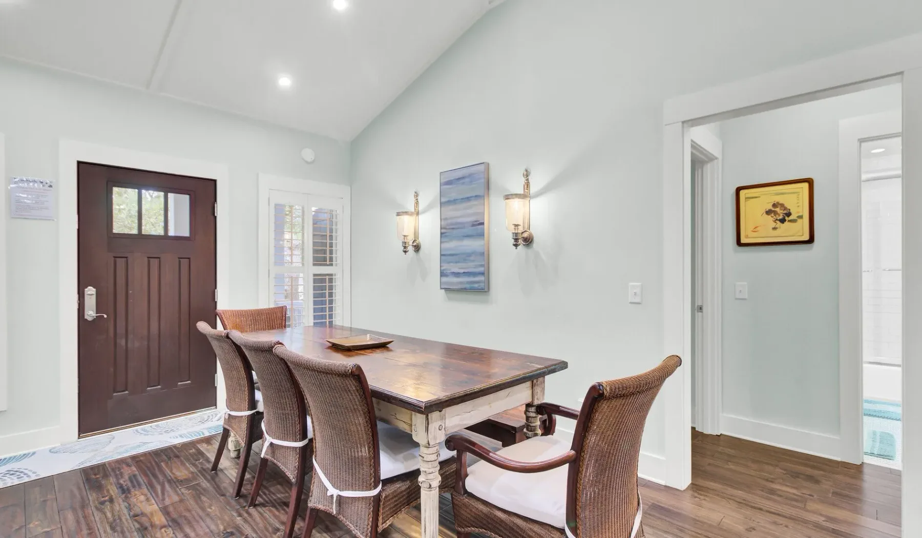 A dining area with a wooden table and chairs beside the entry door.