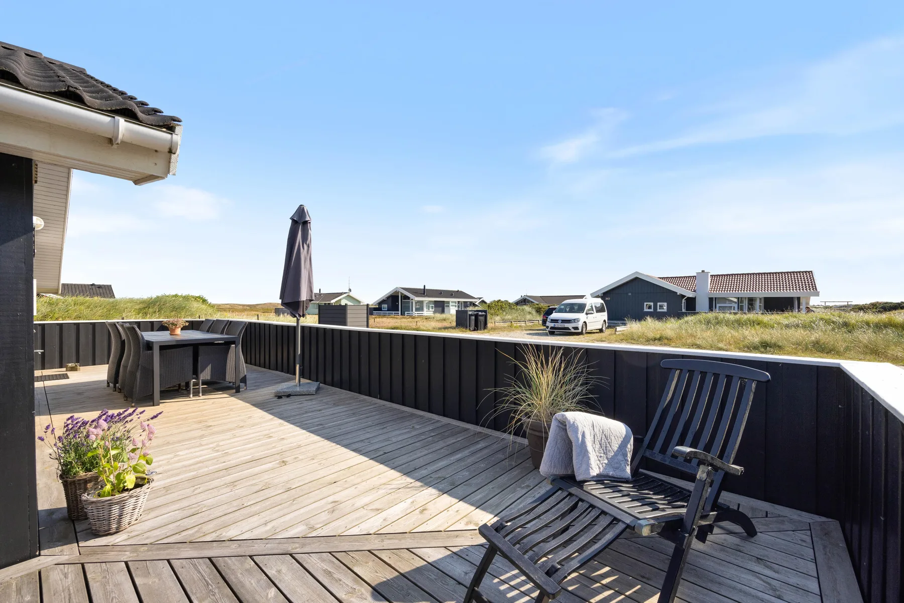 Una terraza exterior con asientos y vistas a casas cercanas.