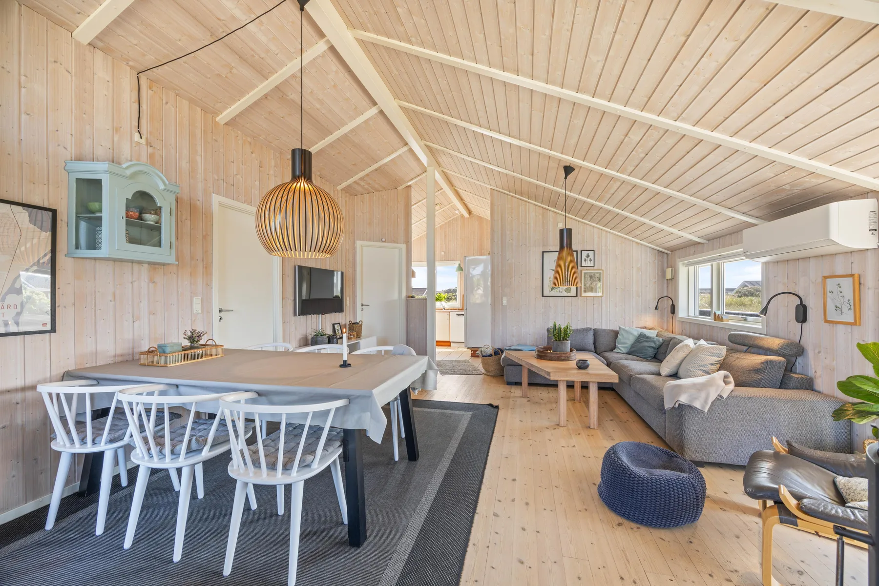 Un luminoso salón-comedor diáfano con una mesa de comedor y una zona de estar.