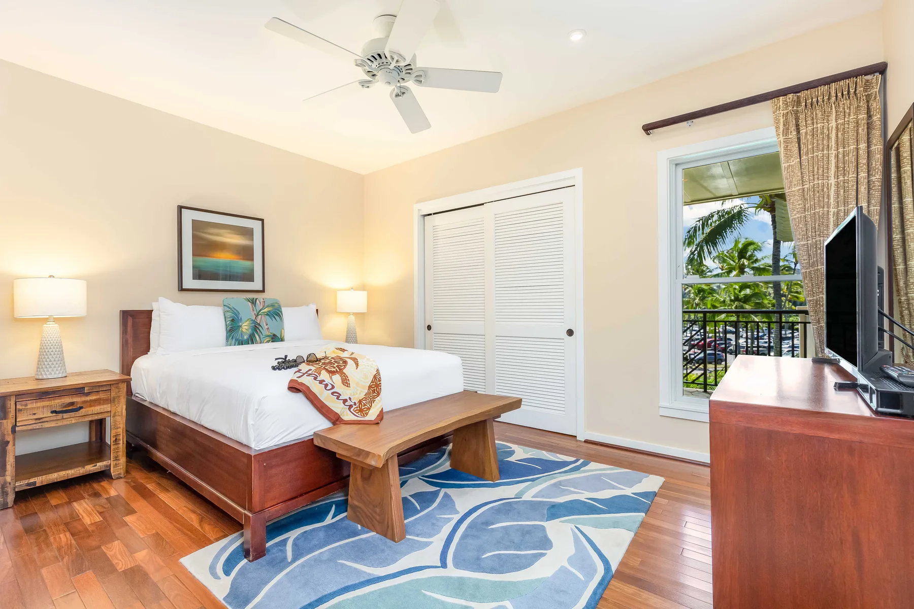 A bedroom with a bed, wooden furnishings, and a ceiling fan.