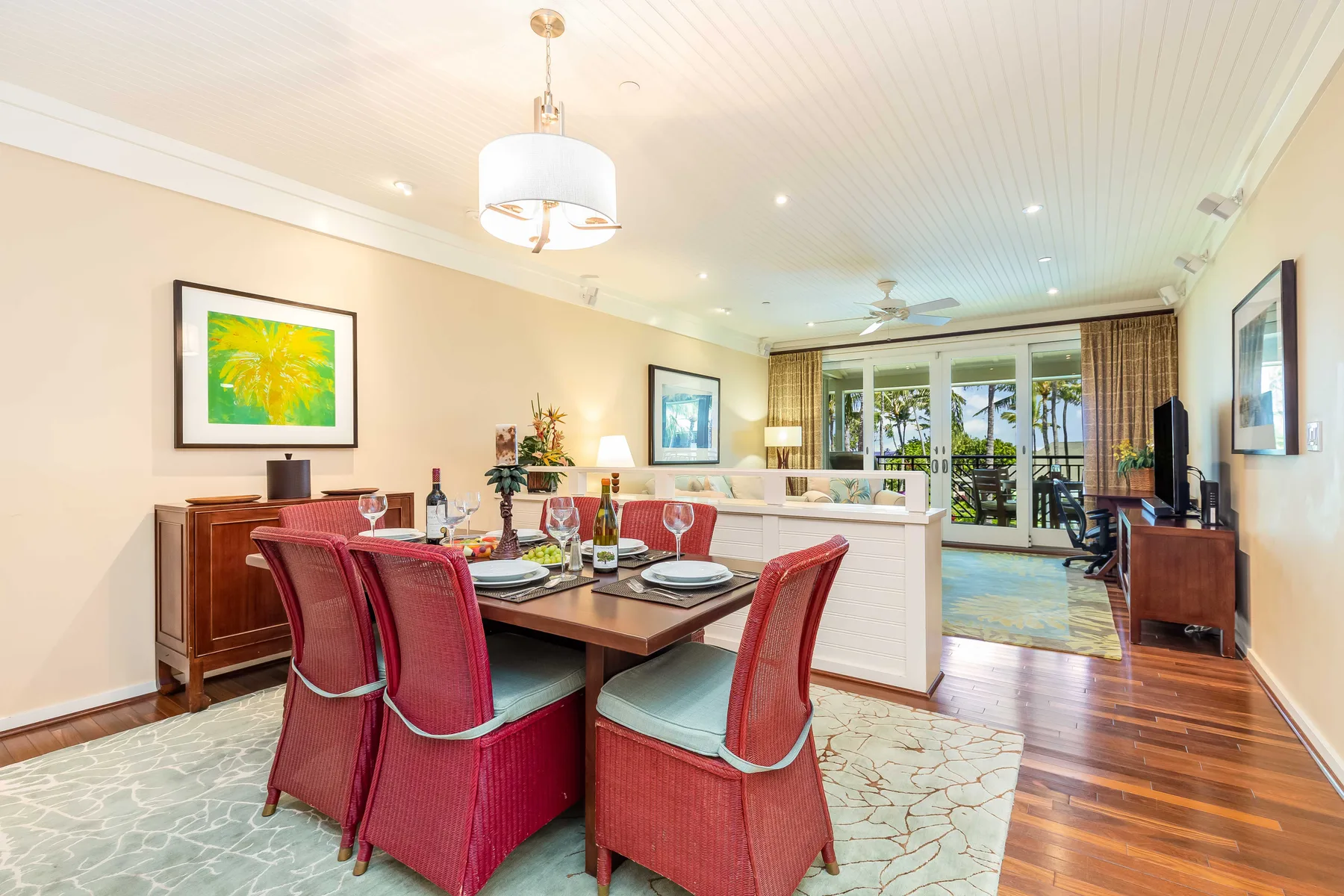 A dining area with red upholstered seating beside an open living room.