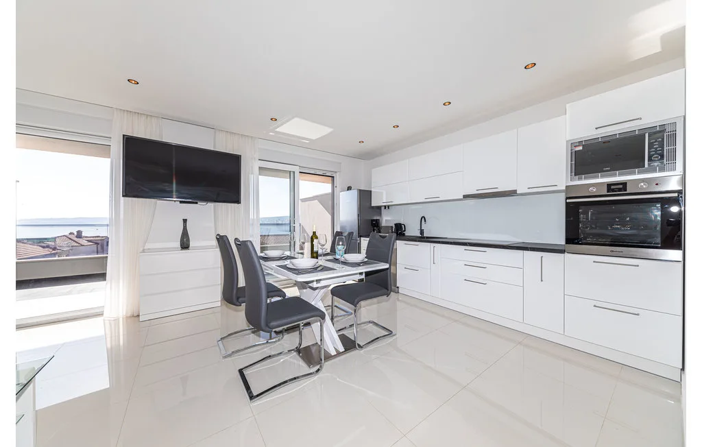 Una cocina moderna y luminosa con mesa de comedor y grandes ventanas.