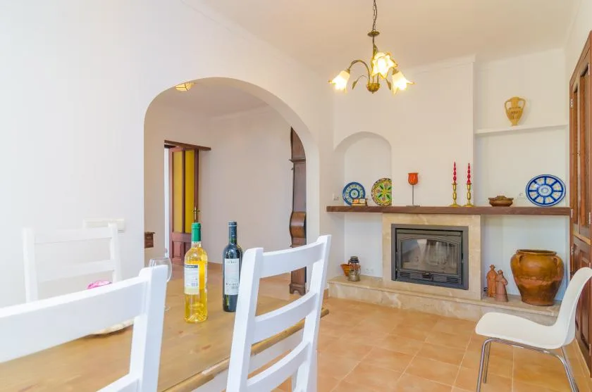 A dining area with a fireplace and decorative objects on the mantel.