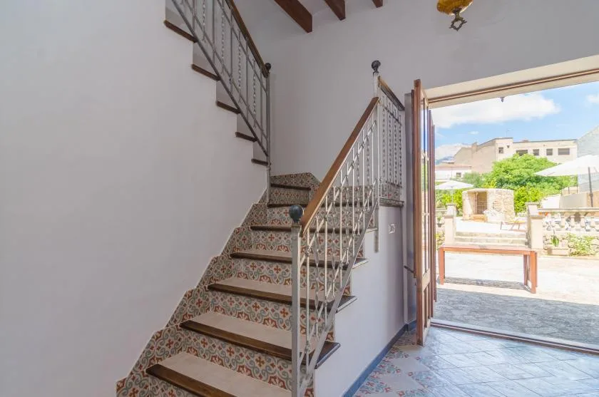 A tiled staircase with decorative railings leads to an open doorway.