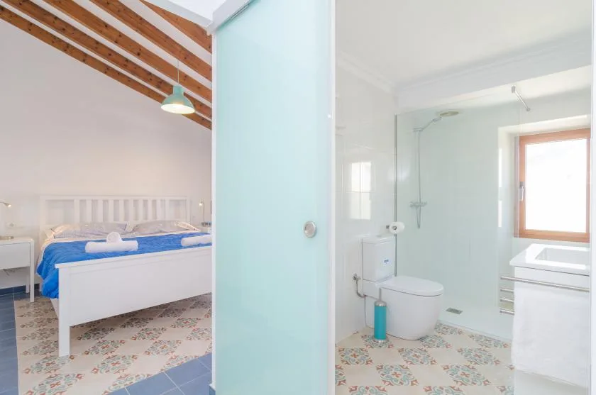 A bedroom and bathroom are visible on either side of a pale blue partition.