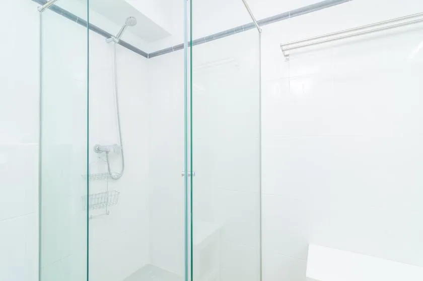 A bright bathroom with a glass shower and wall-mounted shower fixtures.