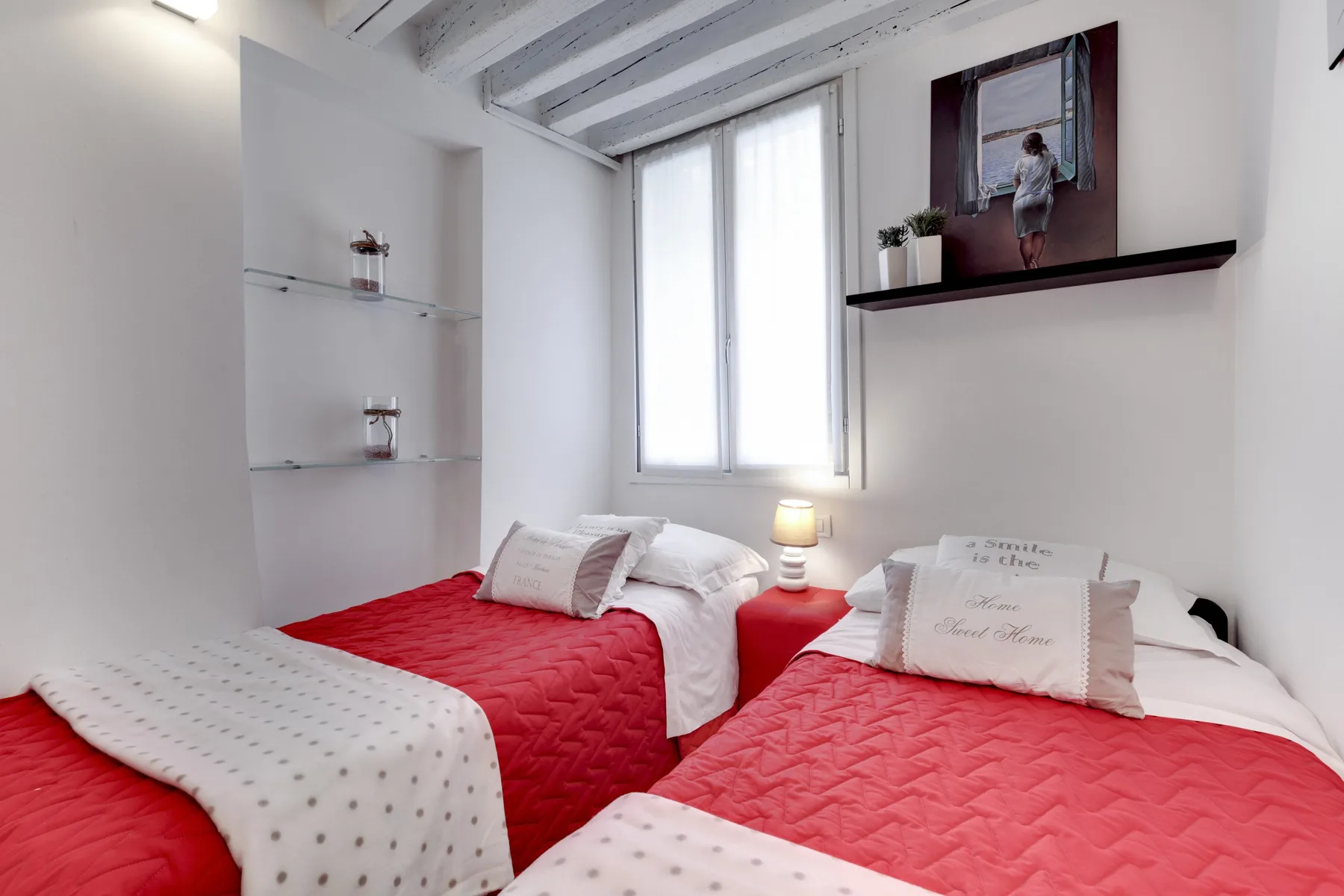 Un dormitorio con dos camas vestidas con ropa de cama roja y blanca.