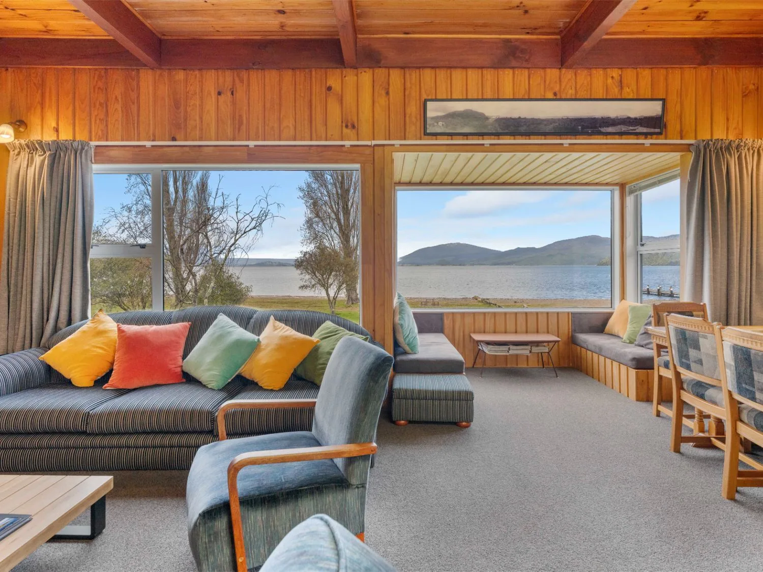 Una sala de estar con un sofá, sillas y vistas al lago en una propiedad