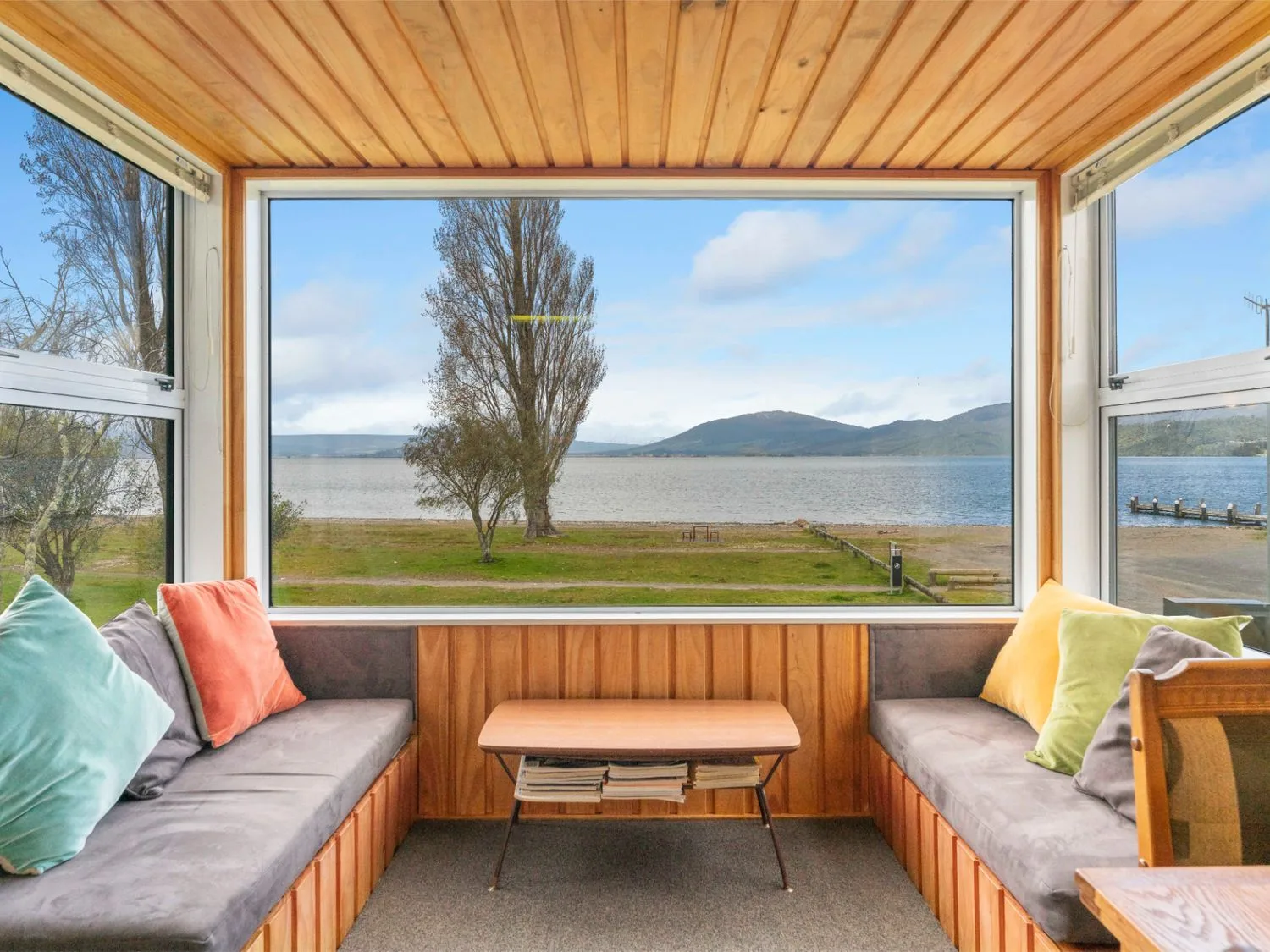A sunroom with a view of a lake and mountains at the property