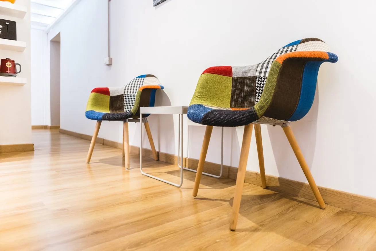 A bright room with colorful seating around a small table.
