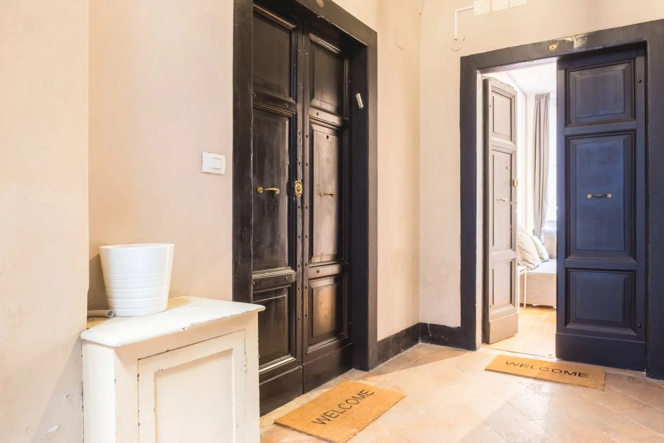 An entry hall with dark paneled doors and a small white console.