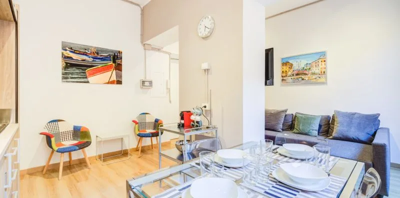 Una sala de estar con una mesa puesta con platos frente a un sofá.