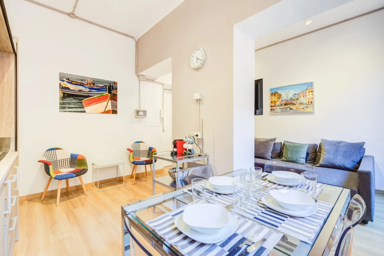 A bright dining area with a glass table set beside a seating area.