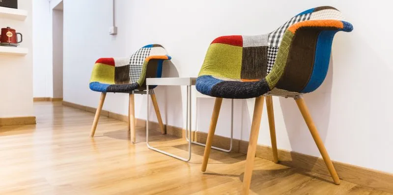 A bright room with colorful upholstered seating and a small table.