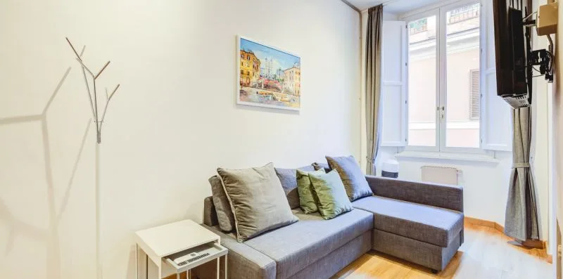 A living room with a gray sectional sofa beside a bright window.