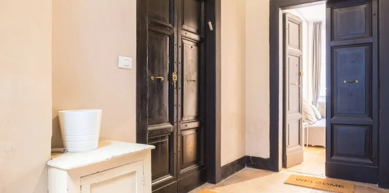 An interior hallway with dark paneled doors and a small white table.