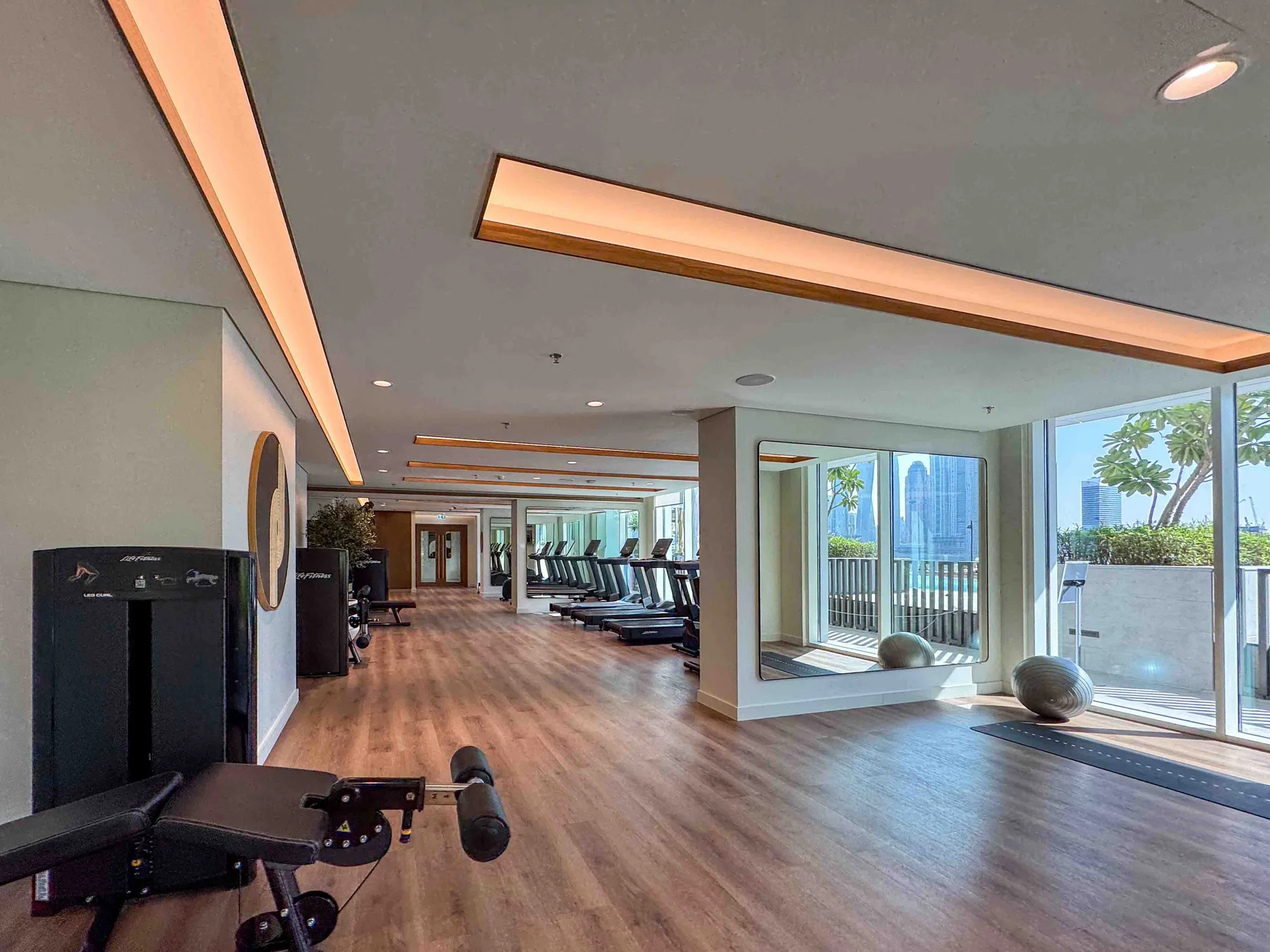 Una sala de ejercicio con equipos de entrenamiento y grandes ventanas con vista al agua.