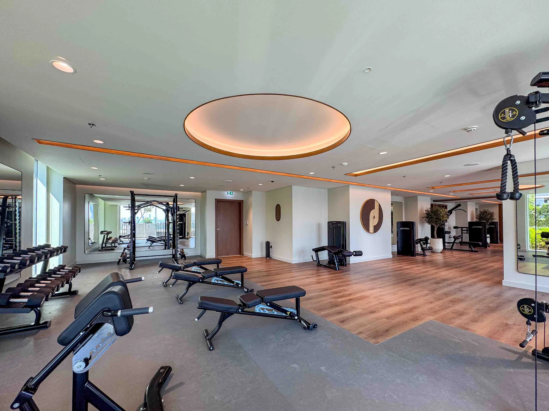 Un gimnasio con máquinas de pesas y bancos de ejercicio distribuidos por la sala.