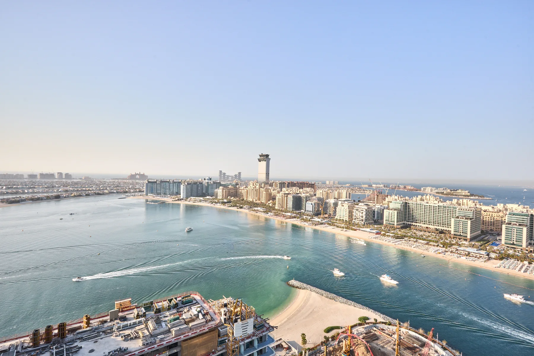 Vista aérea de una ciudad costera con edificios junto al agua y barcos.