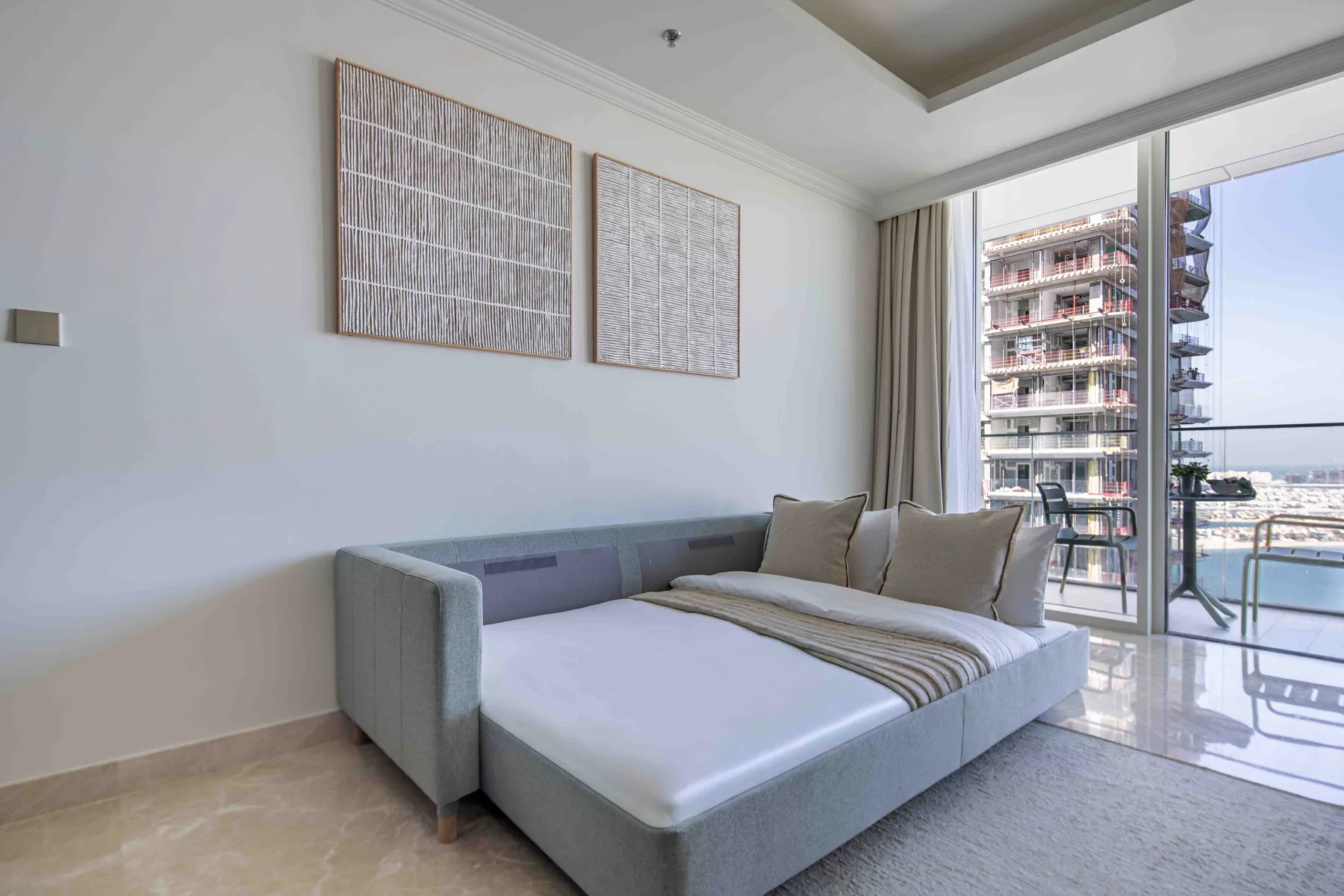 Un dormitorio con una cama grande junto a ventanales de piso a techo.
