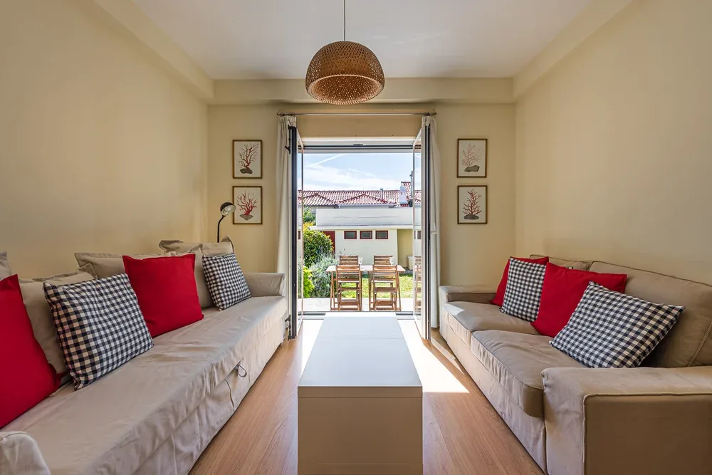 A living room with facing seating and an open doorway to a patio.