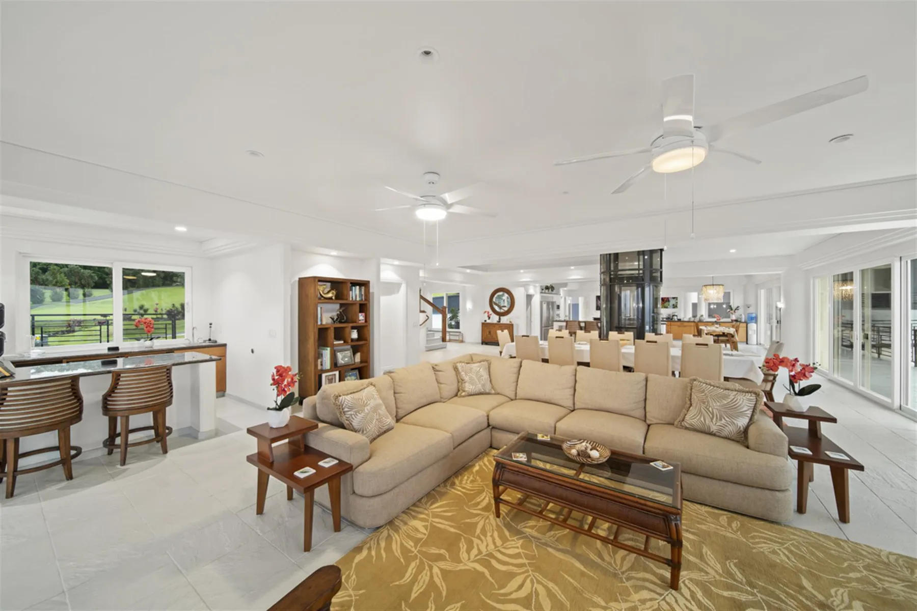 A bright open-plan living and dining area with sectional seating and a dining table.