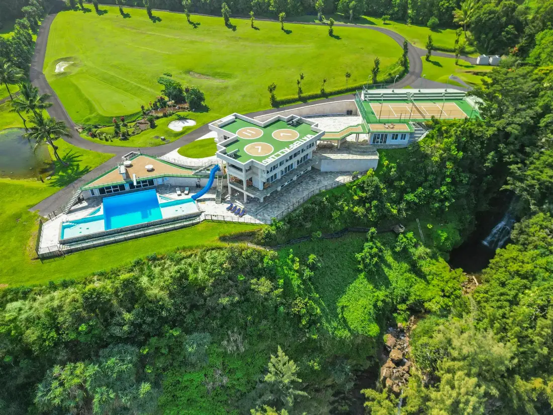 An aerial view shows a recreation complex with a swimming pool and sports courts.