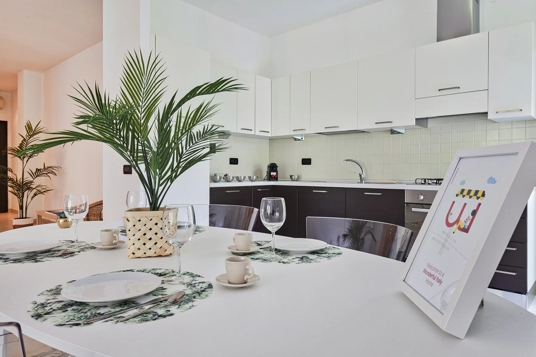Un comedor luminoso con una mesa puesta junto a una cocina moderna.