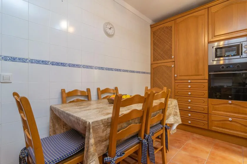 A dining area with a table, wooden seating, and built-in cabinetry.