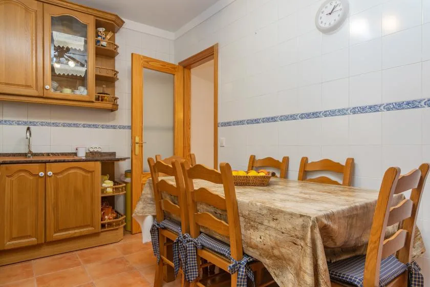 A dining area with a wooden table and chairs beside built-in cabinets.
