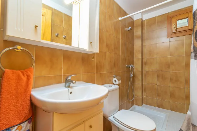 A tiled bathroom with a sink, toilet, and shower.